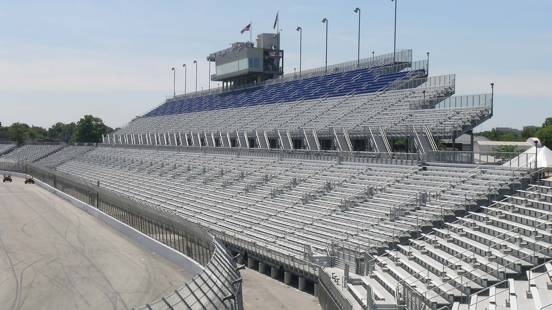 A view of the large grandstand at Milwaukee Mile Speedway, complete with aluminum bench seating and a press box.