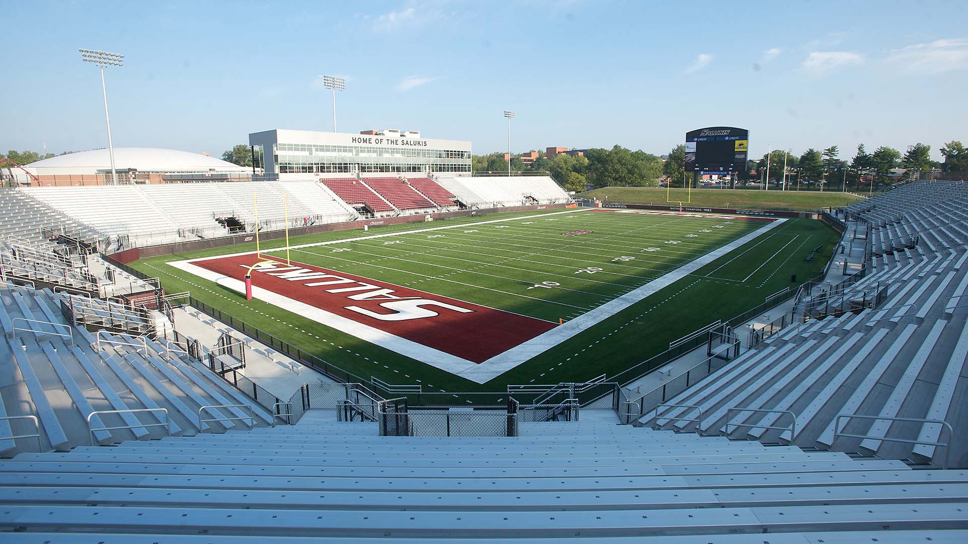 Saluki Stadium includes a large horseshoe grandstand with aluminum bench seats.