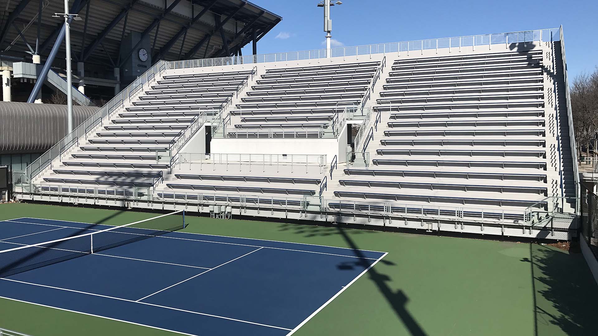 The grandstand at USTA South Campus, featuring aluminum bench seats.