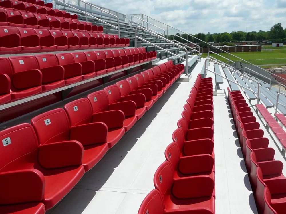 Sunny outdoor photo of red seating at Wayne High School. Colosseum seating option.