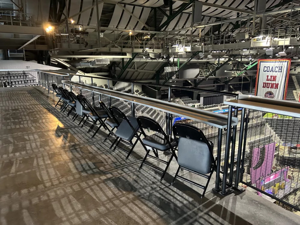 Drink rail in the upper bowl of Gainbridge Fieldhouse home of the Indiana Pacers features wire mesh railing with an aluminum countertop