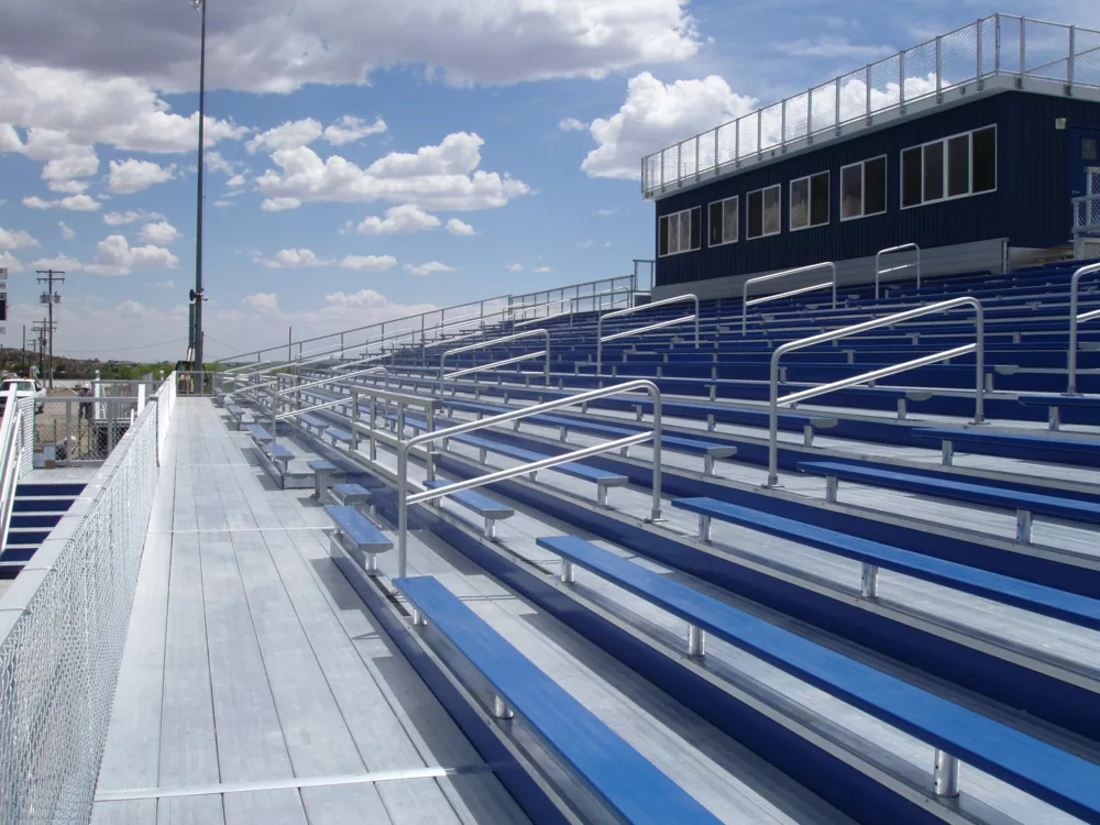 aluminum bleacher with bench seating, handicap inset pockets and press box with blue vinyl siding
