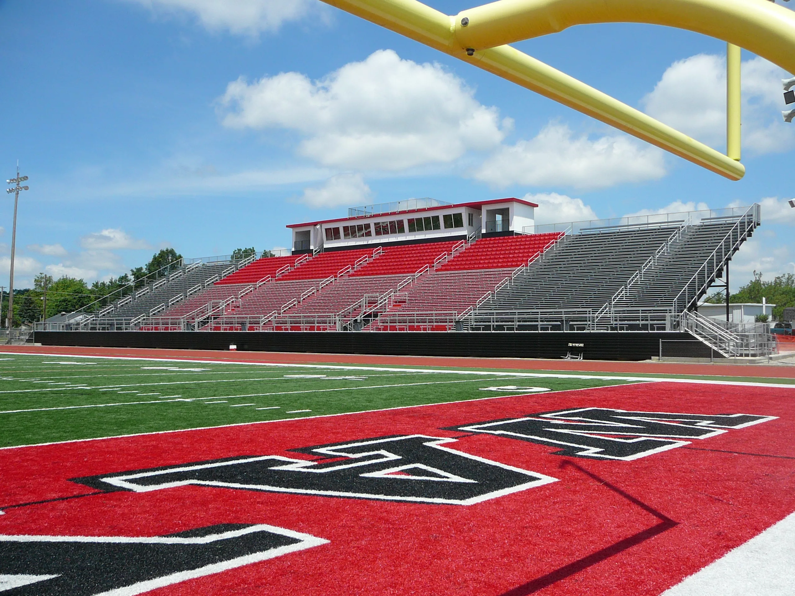 colorful grandstand with VIP seating section and large press box with multiple rooms.