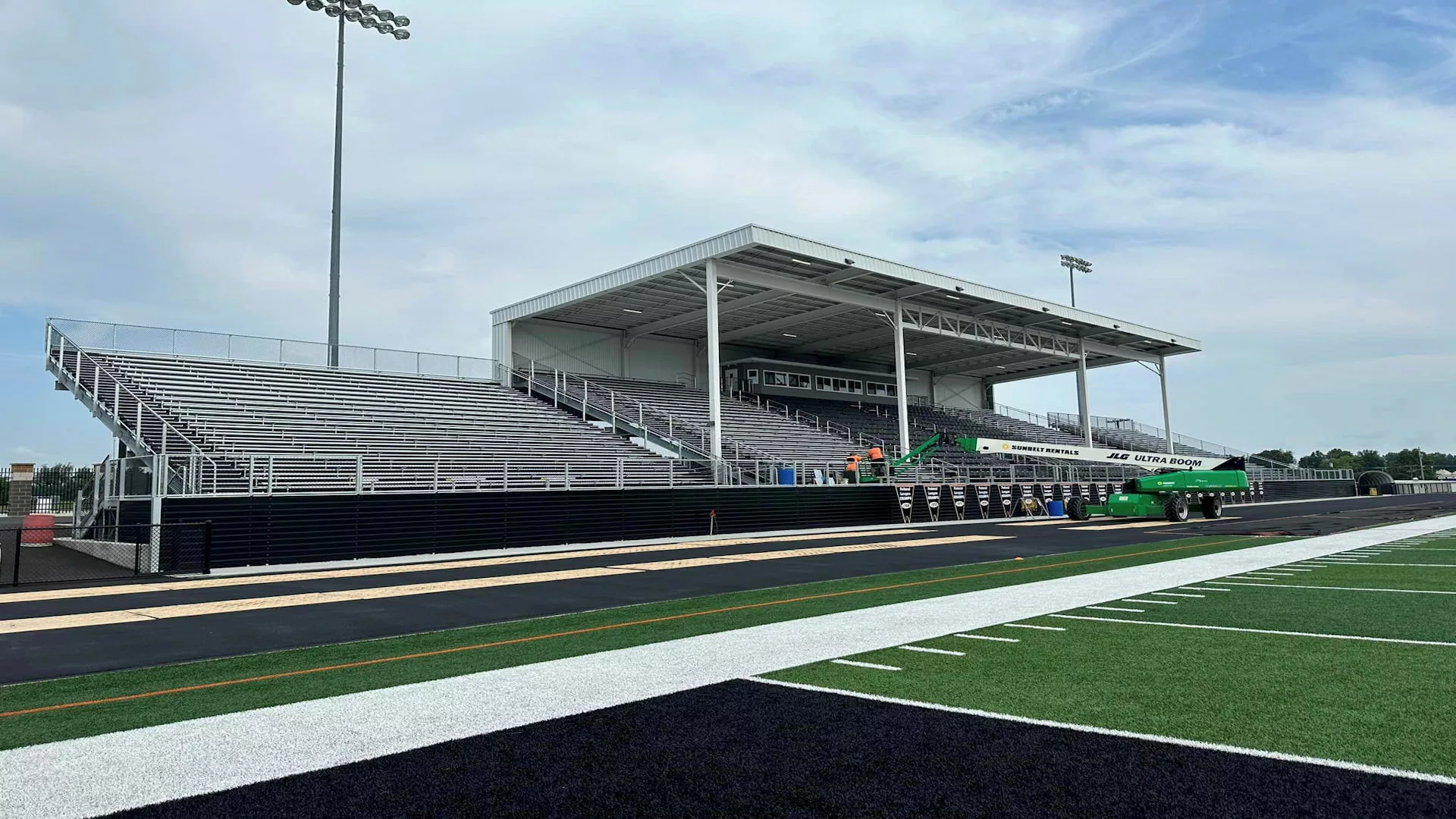large I-beam grandstand with three sections of seating, VIP chair seating in center section with large roof structure spanning the middle seating section and press box